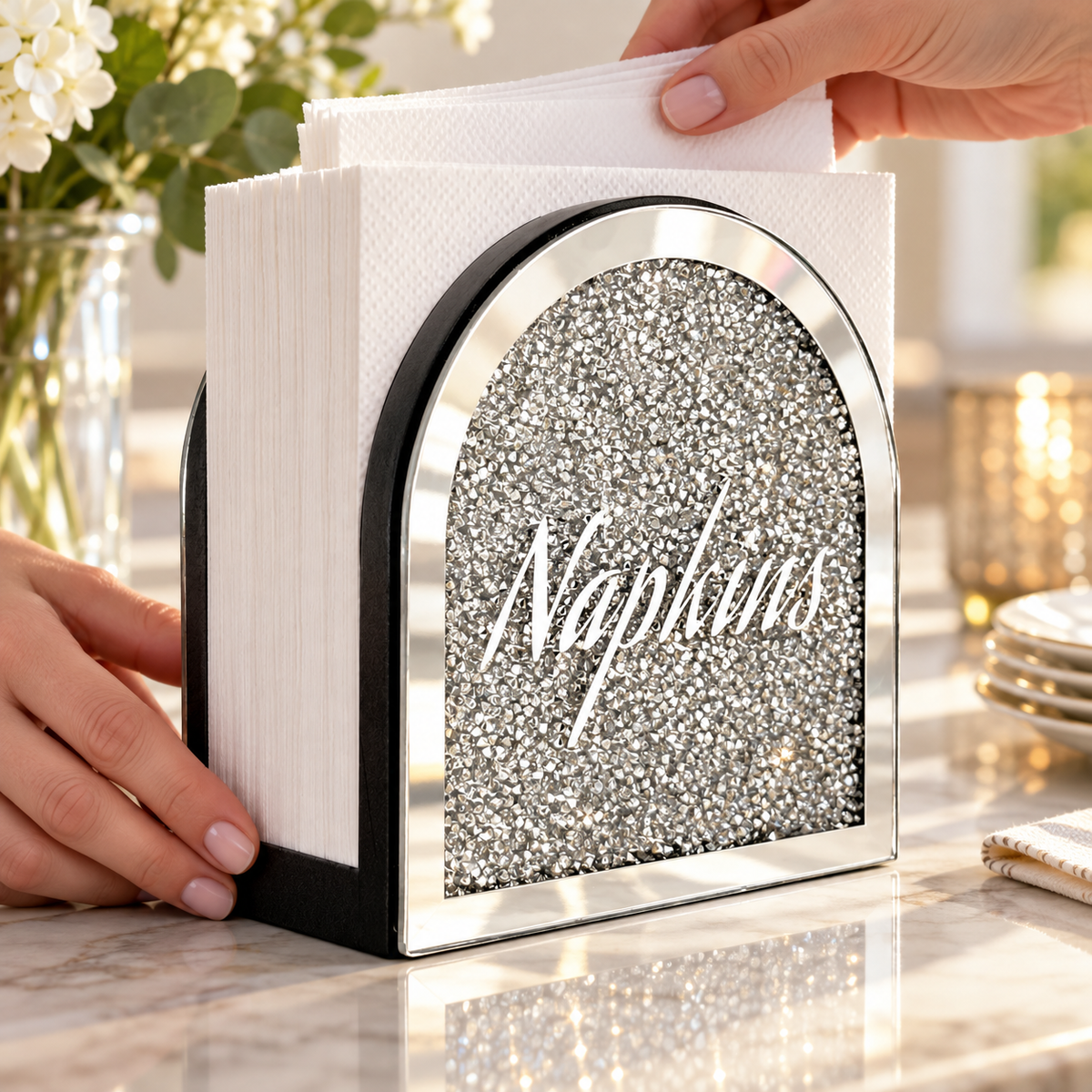 Adding napkins to the mirrored holder. Napkins and styling props not included. AI-generated product visualization.