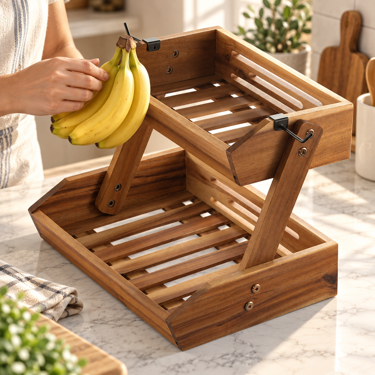 Hands supporting a small banana bunch near one hook of the otherwise empty two-tier wooden stand. Fruit and clothing are props, not included.