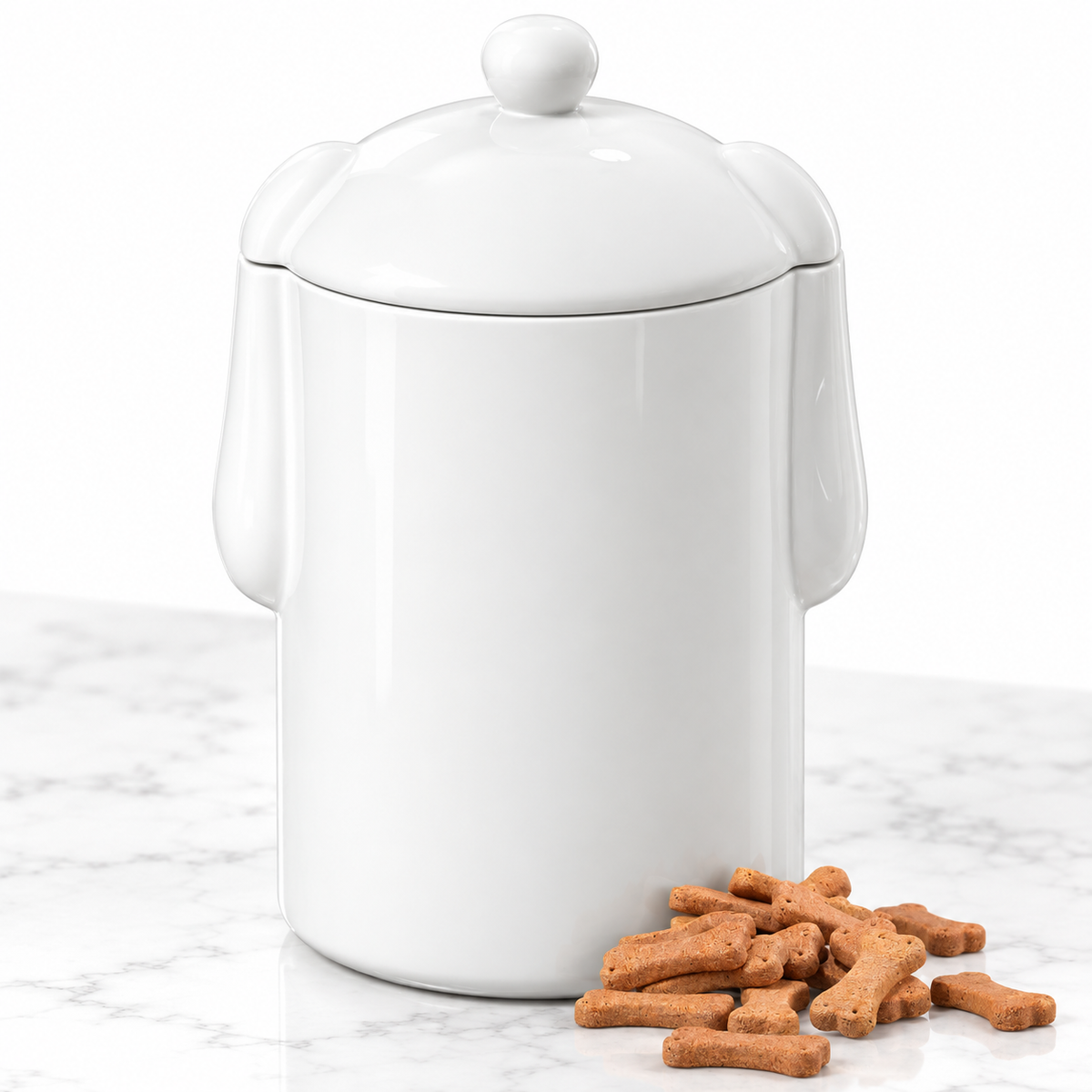 Closed white dog-ear treat jar beside bone-shaped biscuits on a white surface; biscuits are styling props, not included.