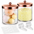 Two clear jars with closed rose-gold lids, two clear scoops and sample blank labels; bath balls and crystals are styling props, not included.