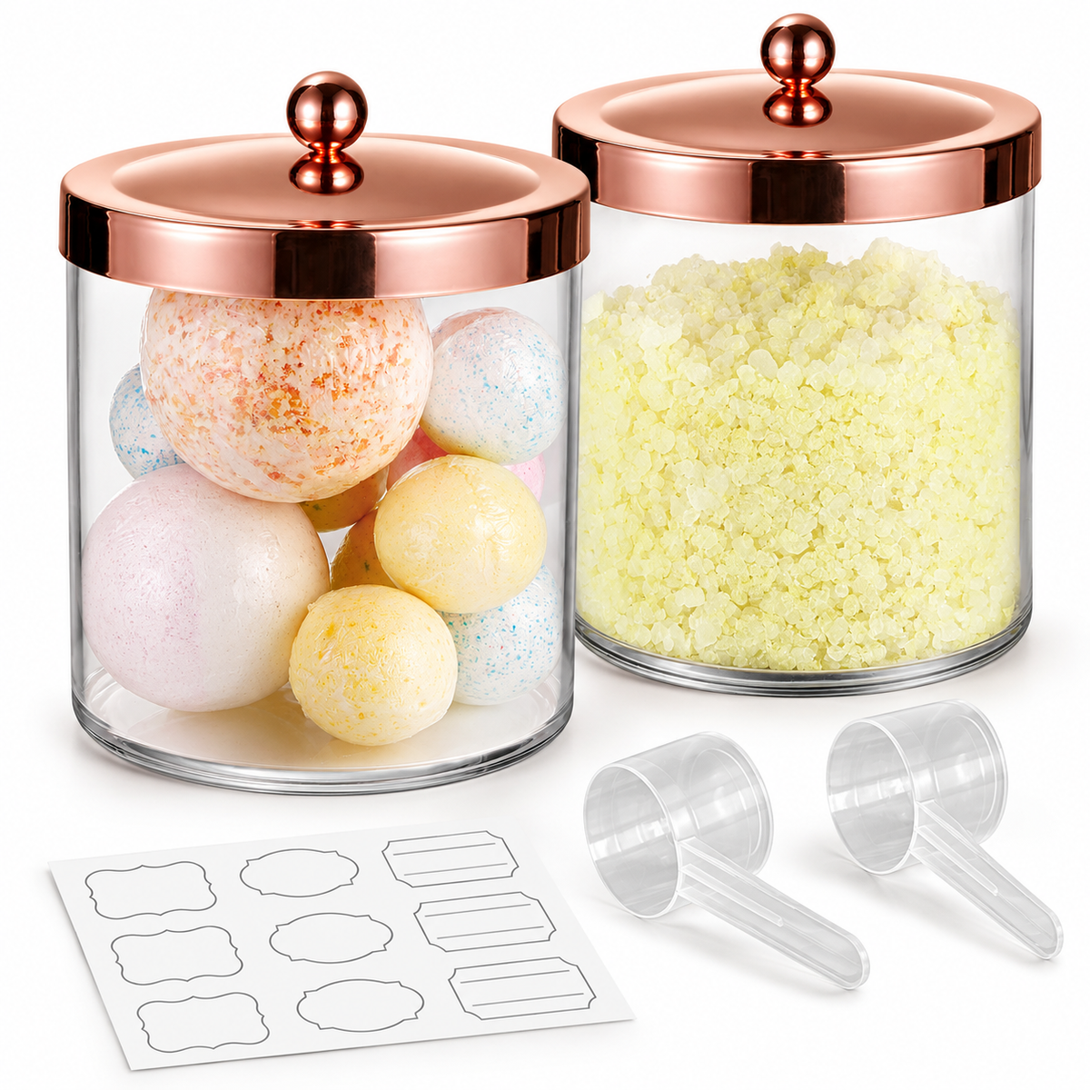 Two clear jars with closed rose-gold lids, two clear scoops and sample blank labels; bath balls and crystals are styling props, not included.