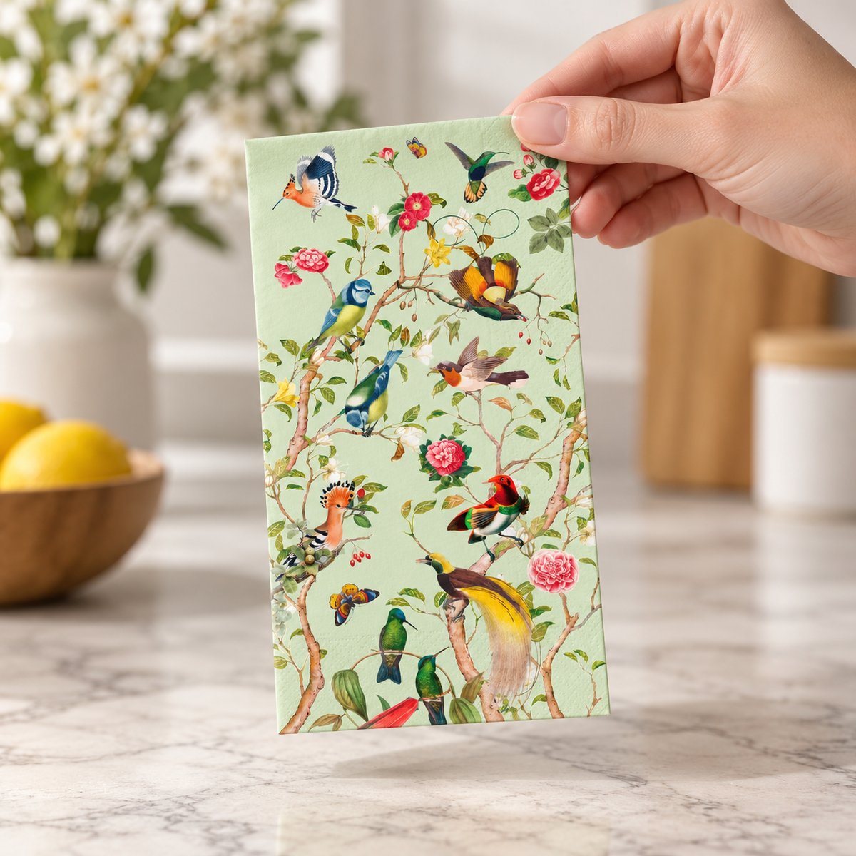green bird guest napkin shown with a hand for scale
