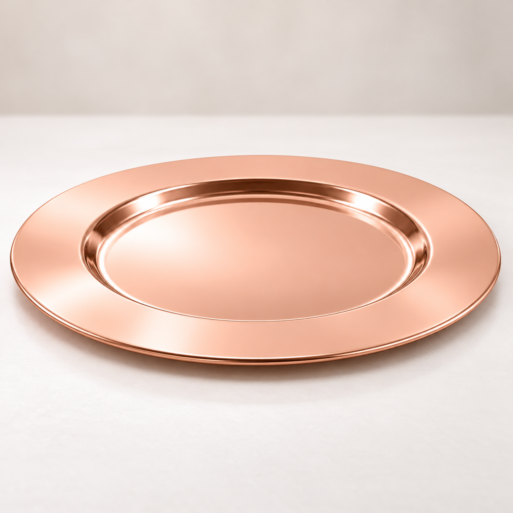 Low-angle view of an empty rose-gold stainless steel charger showing the broad smooth rim, shallow recessed center and thin edge.