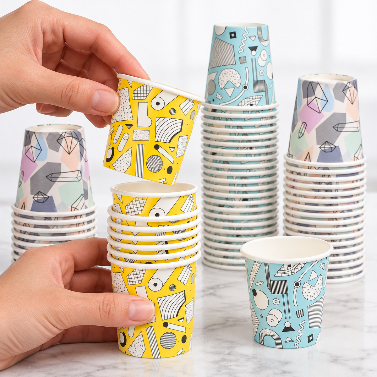 Adult hands separate a yellow mini cup from its nesting stack.