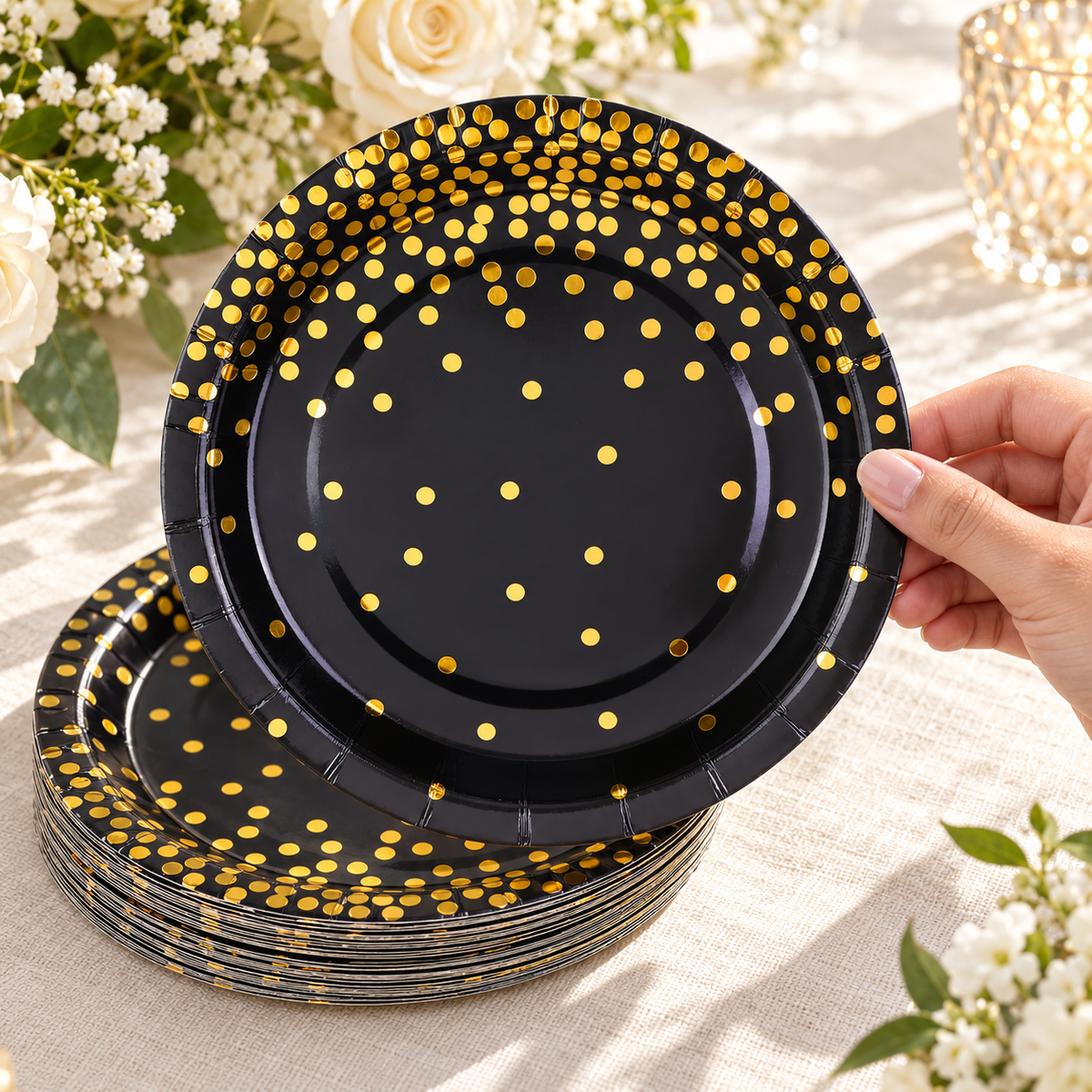 A guest taking a black paper plate with gold dots. Food, tableware and decor are styling props, not included.