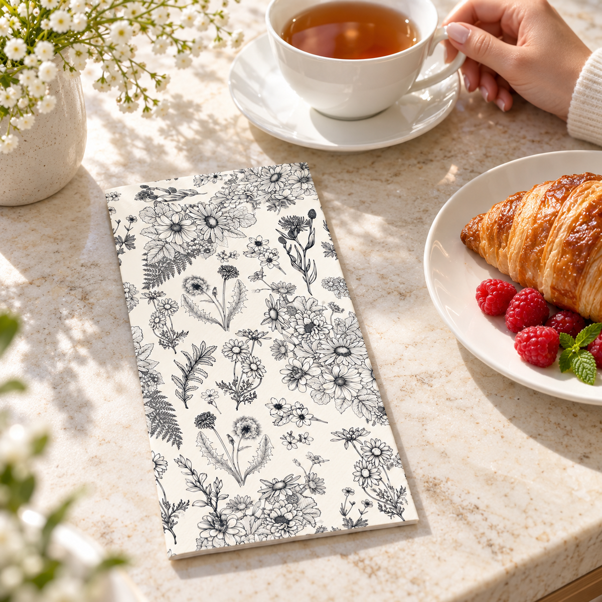 Black and white botanical paper guest napkins in a morning tea and pastry setting. Other tableware, food and decor are styling props, not included.