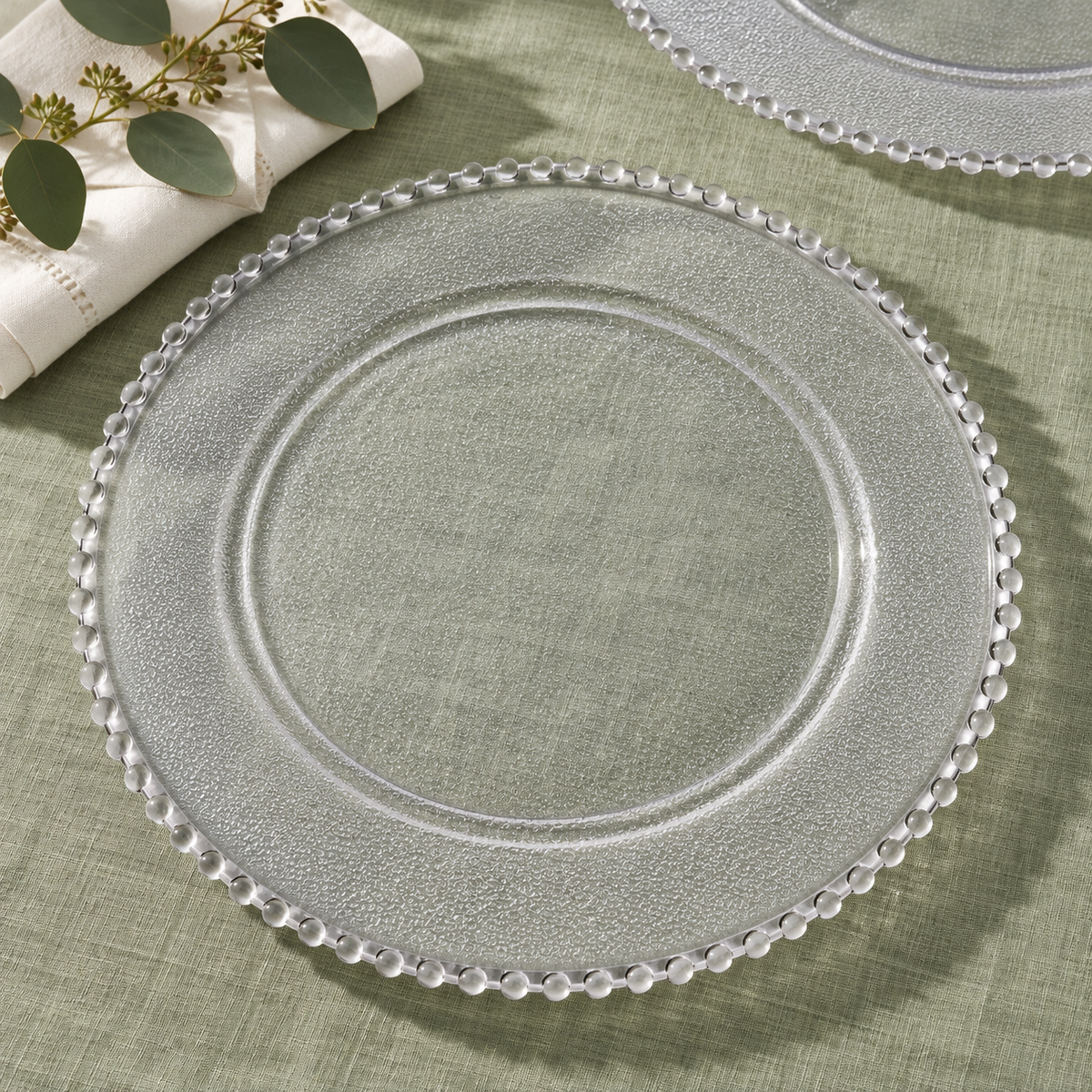 Beaded Clear Charger Plates, 50 pc in a styled product photograph. Dinner plates, food, flowers and extra decor are styling props, not included.