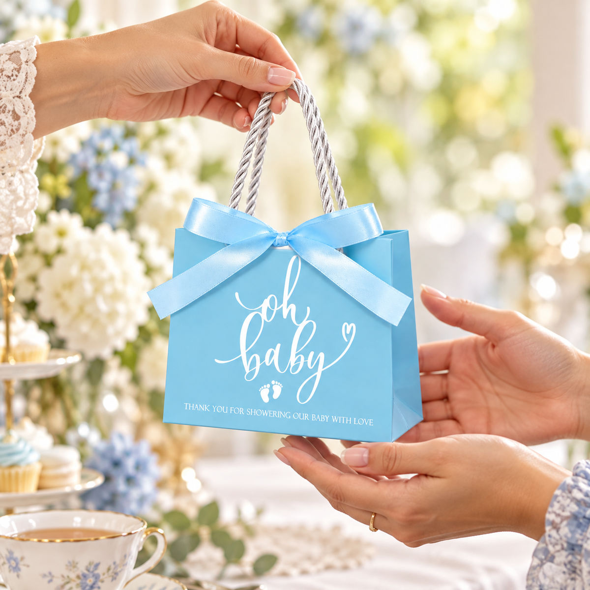 Blue Oh Baby Shower Favour Bags, 25 pc — being handed from one adult to another