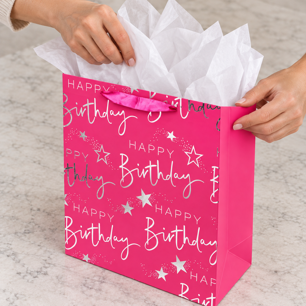 Pink and Silver Birthday Gift Bag with Card with tissue being placed into the opening