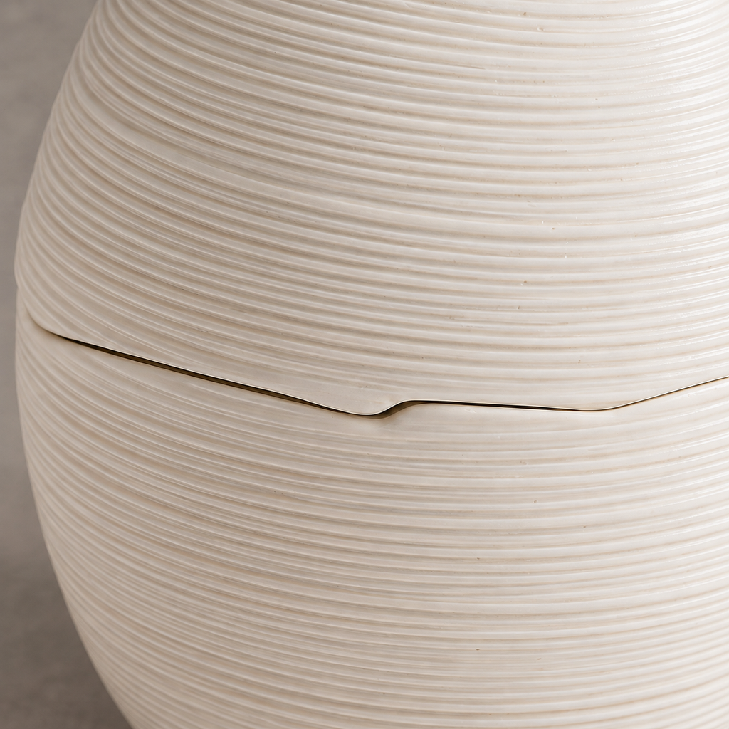 Macro of the egg-shaped ceramic bowl's fine horizontal ridges and fitted lid seam