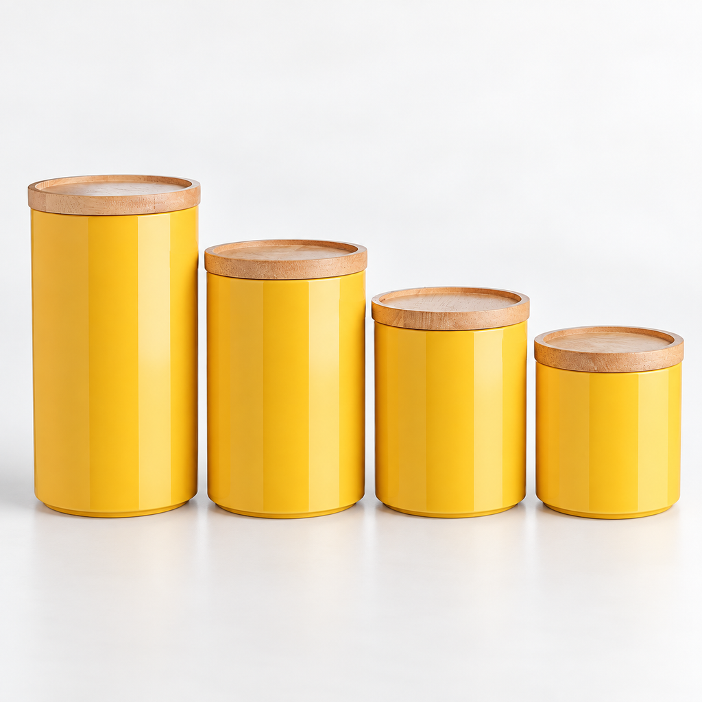 Four closed yellow canisters with recessed wooden lids, arranged by height on a pale surface.
