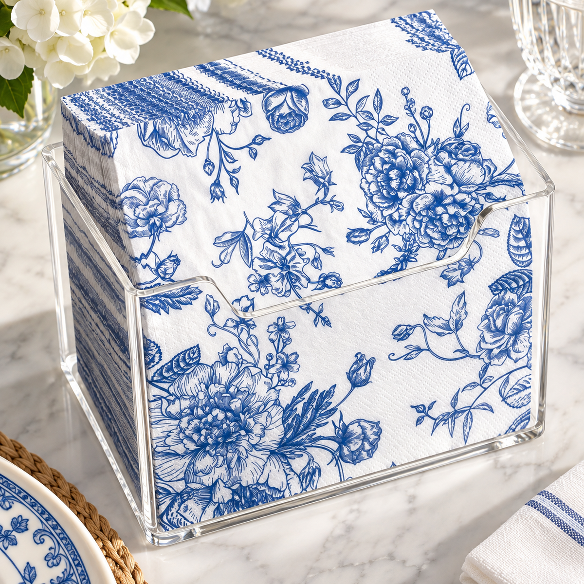High-angle view of the clear acrylic holder filled with floral napkins; napkins not included.