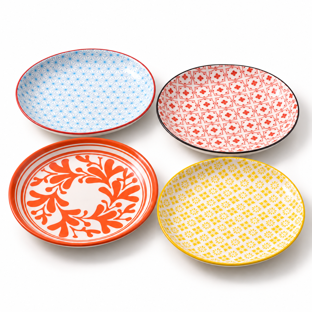 The four 7-inch Japanese-style ceramic plates on white, with blue, red, yellow and orange patterns and their original rim colors.