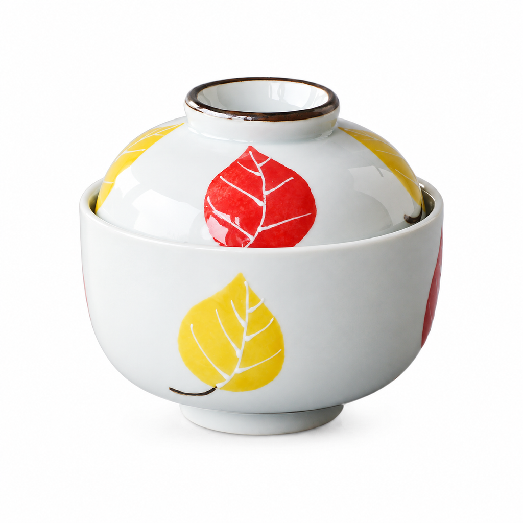 Leaf-pattern ceramic steaming bowl with domed lid on white