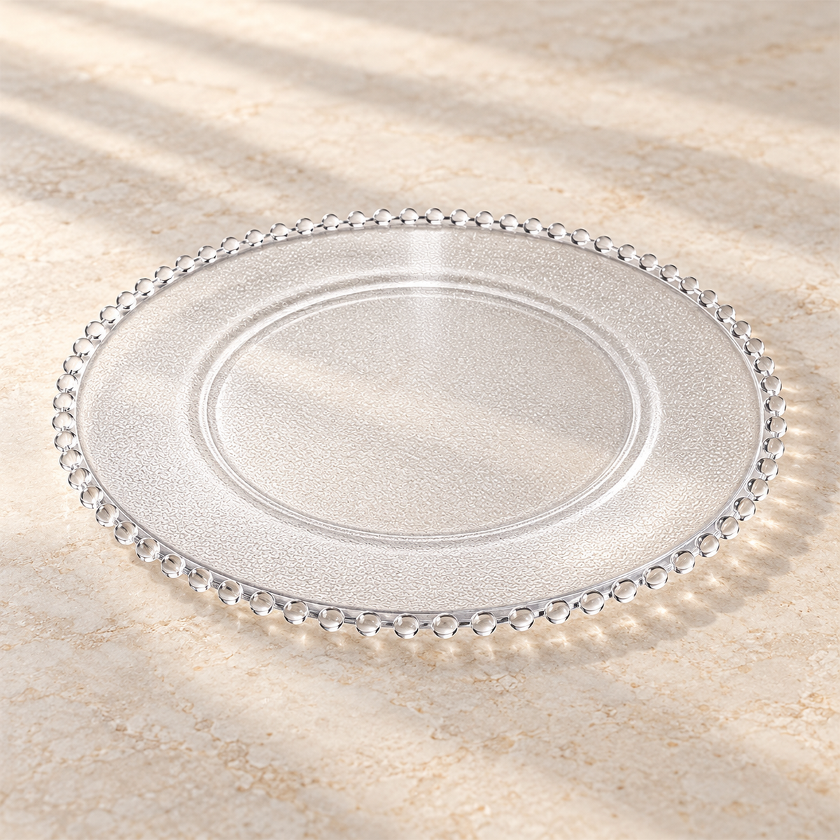 Clear beaded-rim charger with a shallow well and fine texture. Empty low-angle view showing its thin profile.
