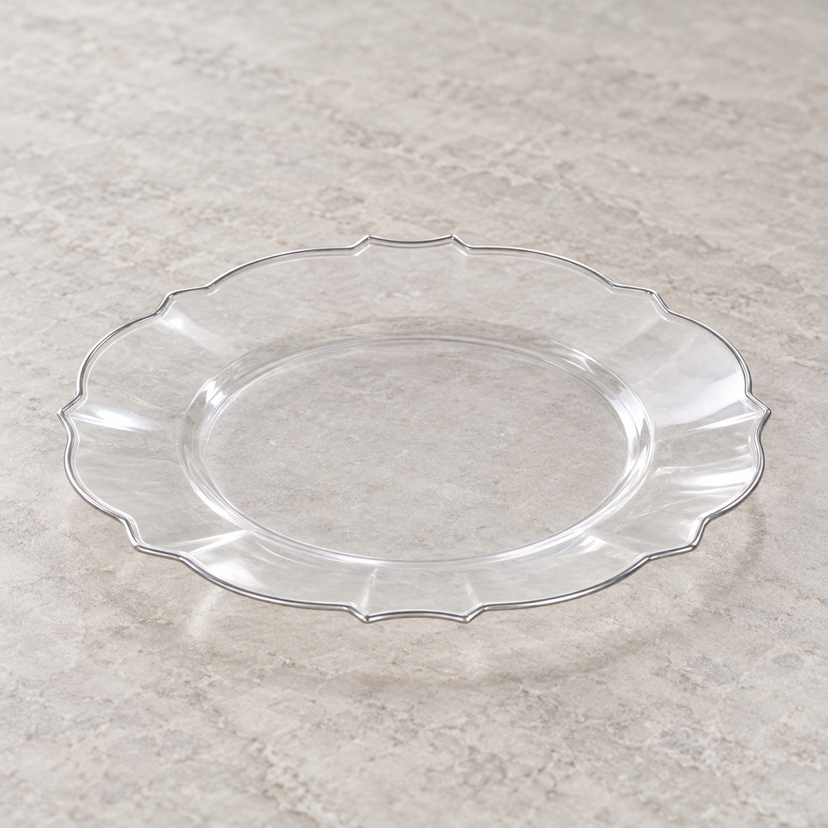 Clear plastic plate with scalloped petal edge and narrow silver rim. Empty angled view showing its shallow profile.