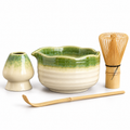 Four-piece green and ivory matcha set with scalloped bowl, holder, bamboo whisk and scoop