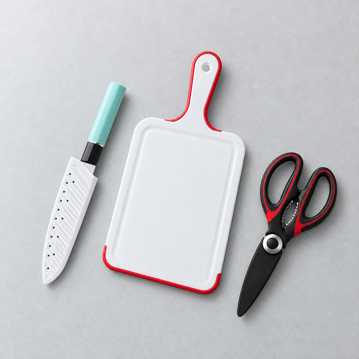 Red-edged white cutting board, mint-handled sheathed knife and black/red scissors
