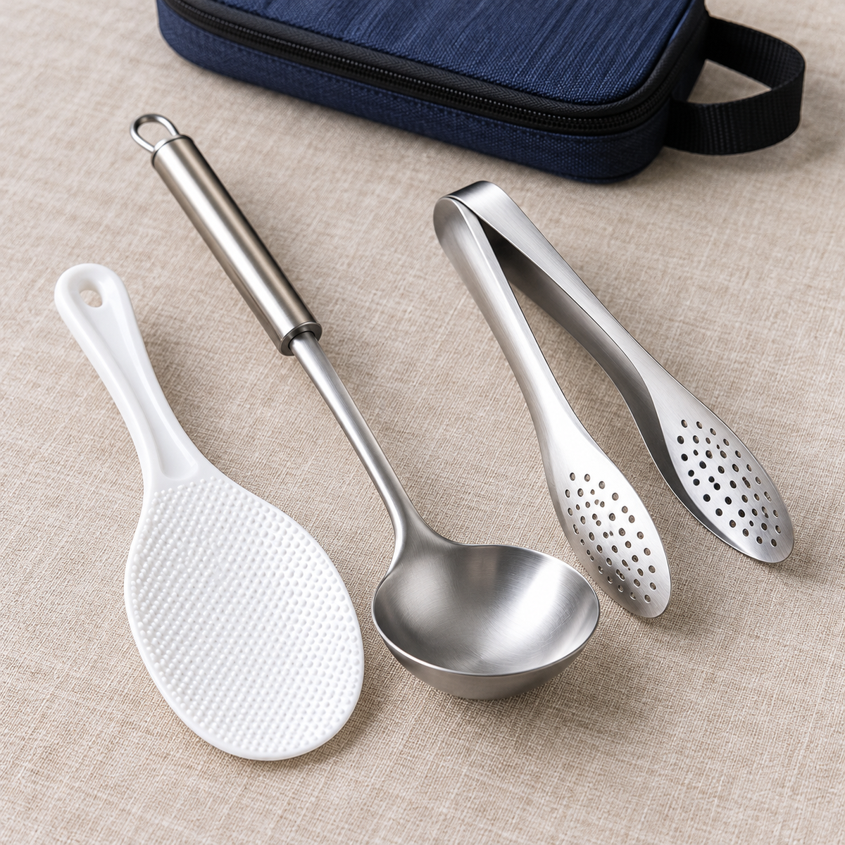 White rice paddle with stainless ladle and tongs; closed navy carry bag partly visible