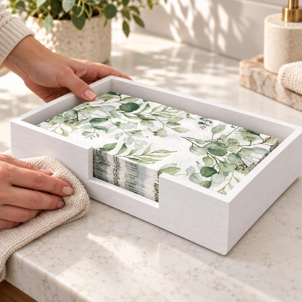 Exterior of white wooden guest towel tray being wiped with a dry cloth; towels are styling props