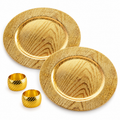 Two representative gold woodgrain chargers and two matching gold napkin rings on white; sample arrangement of the 12-charger and 12-ring set.
