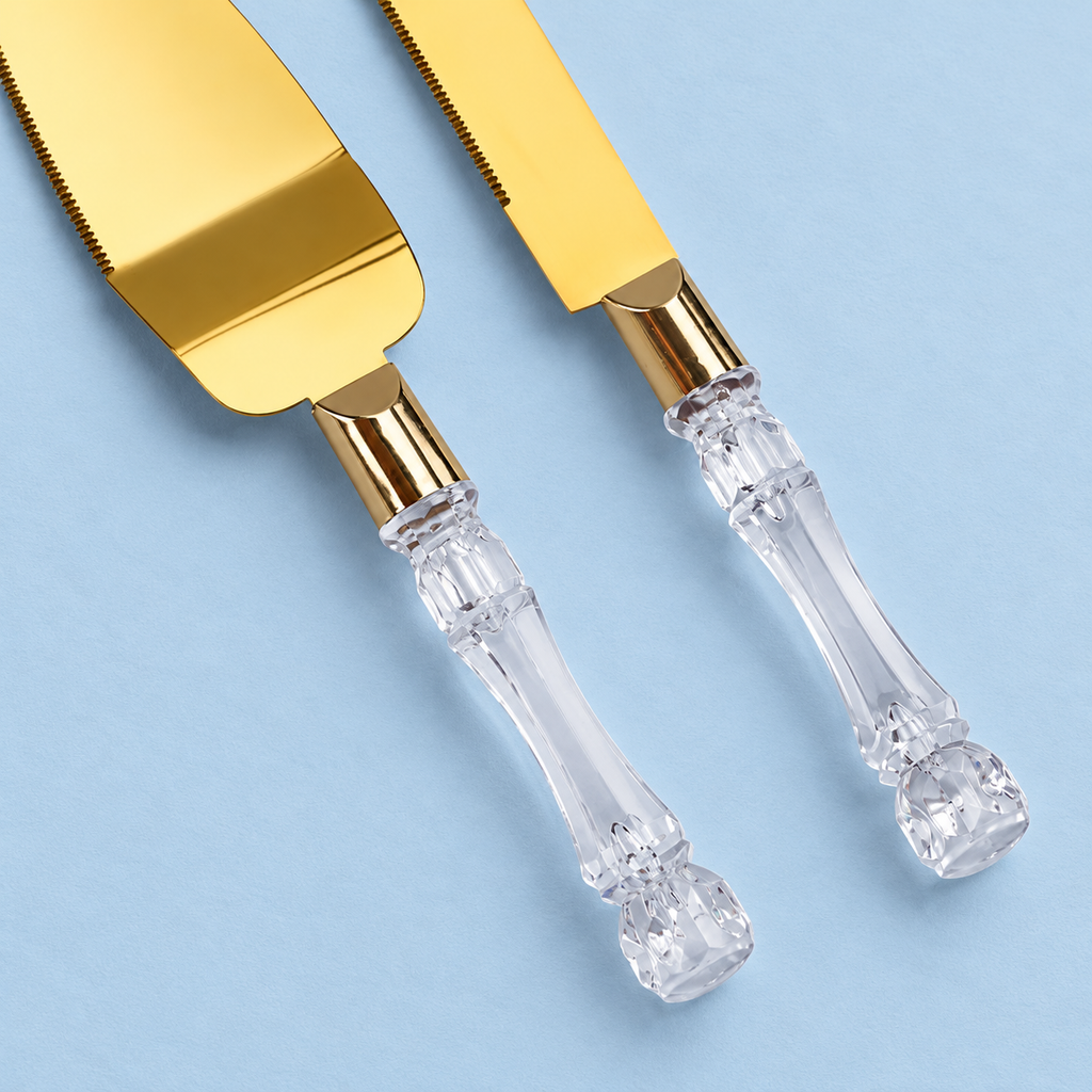 Independent close view of the clear faceted plastic handles and gold-tone collars of the cake knife and server.