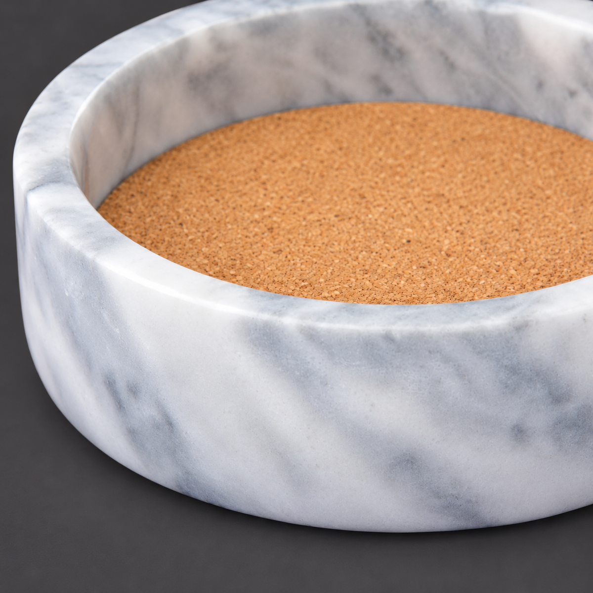 Independent close view of the marble rim, front wall and inset cork edge of the empty coaster.
