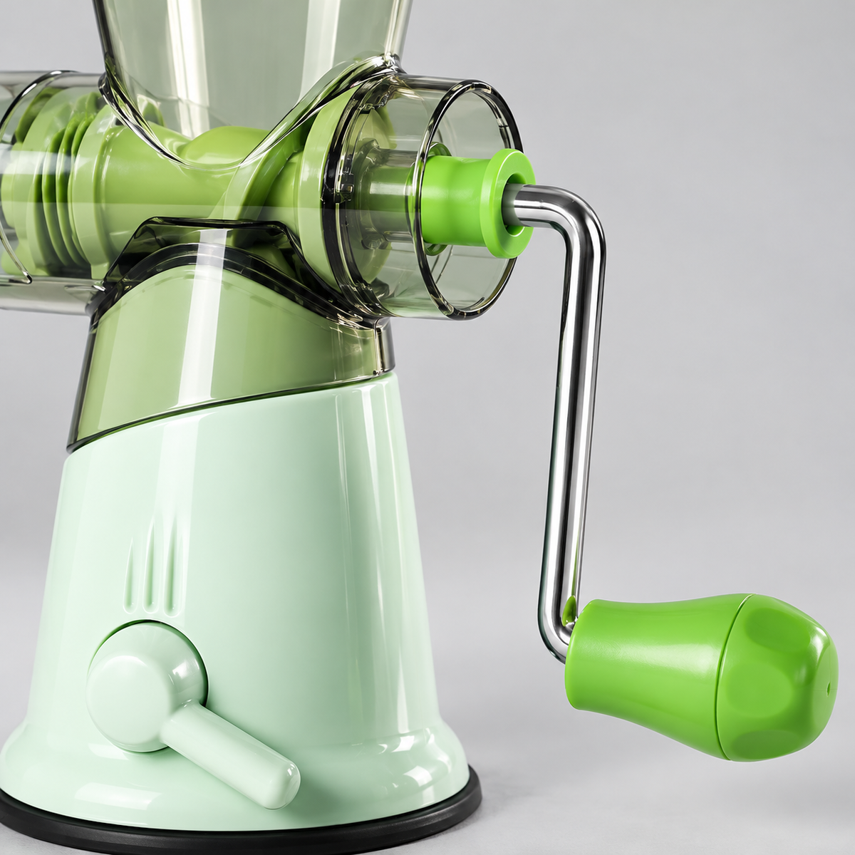Green manual kitchen grinder with clear hopper and hand crank — detail