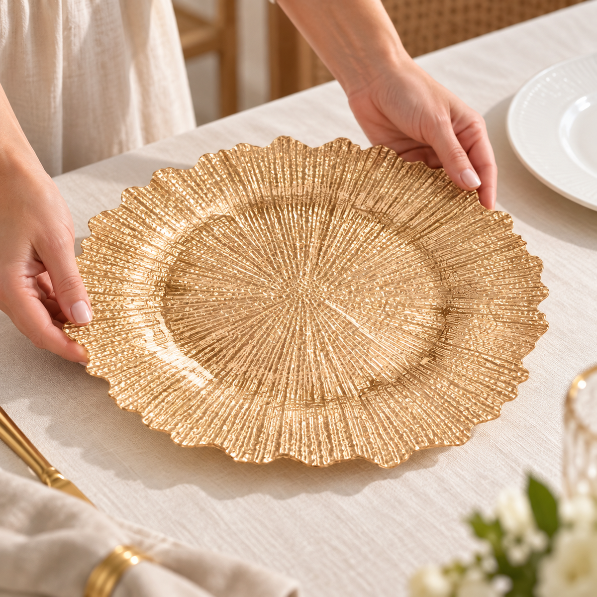Hands placing a gold sunburst glass charger