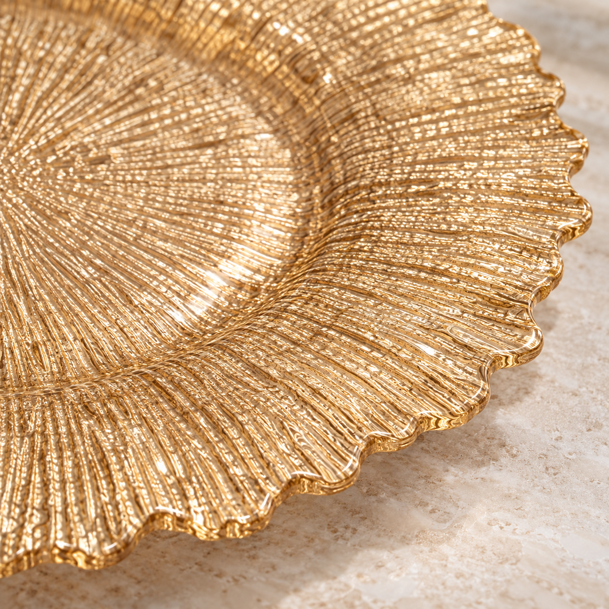 Close detail of gold glass charger texture and scalloped rim