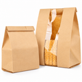 Representative large kraft bag with a vertical clear window and smaller plain-front bag on white. Pack contains 100 large and 20 small bags; bread is a prop.