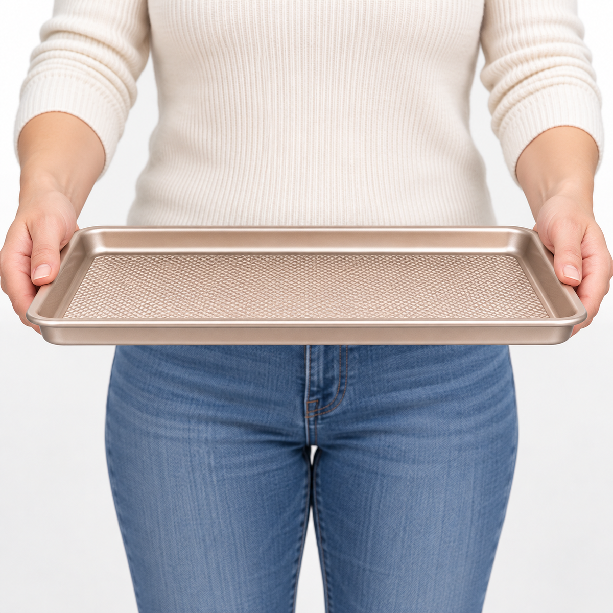 Shallow rectangular gold baking sheet held to show rim profile