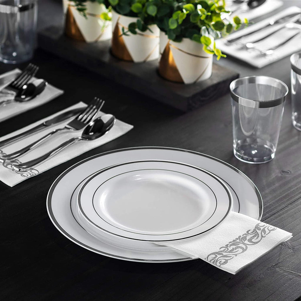 Silver-rim disposable dinnerware with silver-scroll napkin in a table setting; decorative plants not included