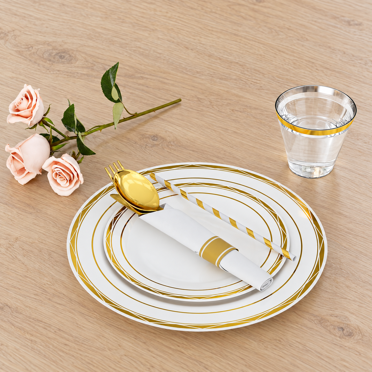 Gold angular-pattern disposable dinnerware with rolled napkin, striped straw and gold-rim cup; flowers and drink are styling props