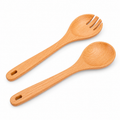 Beech wood salad spoon and four-tine fork on white.