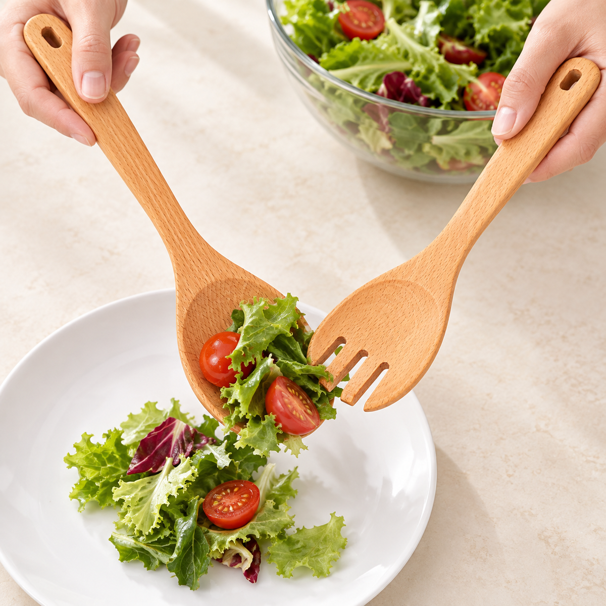 Wood servers placing salad on a plate; food, plate and bowl are styling props, not included.