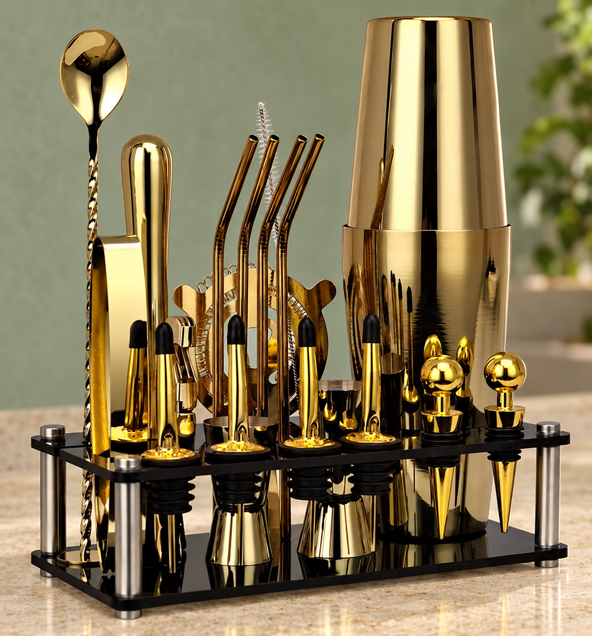 Gold finish Boston cocktail shaker and visible bar tools in black stand on a countertop