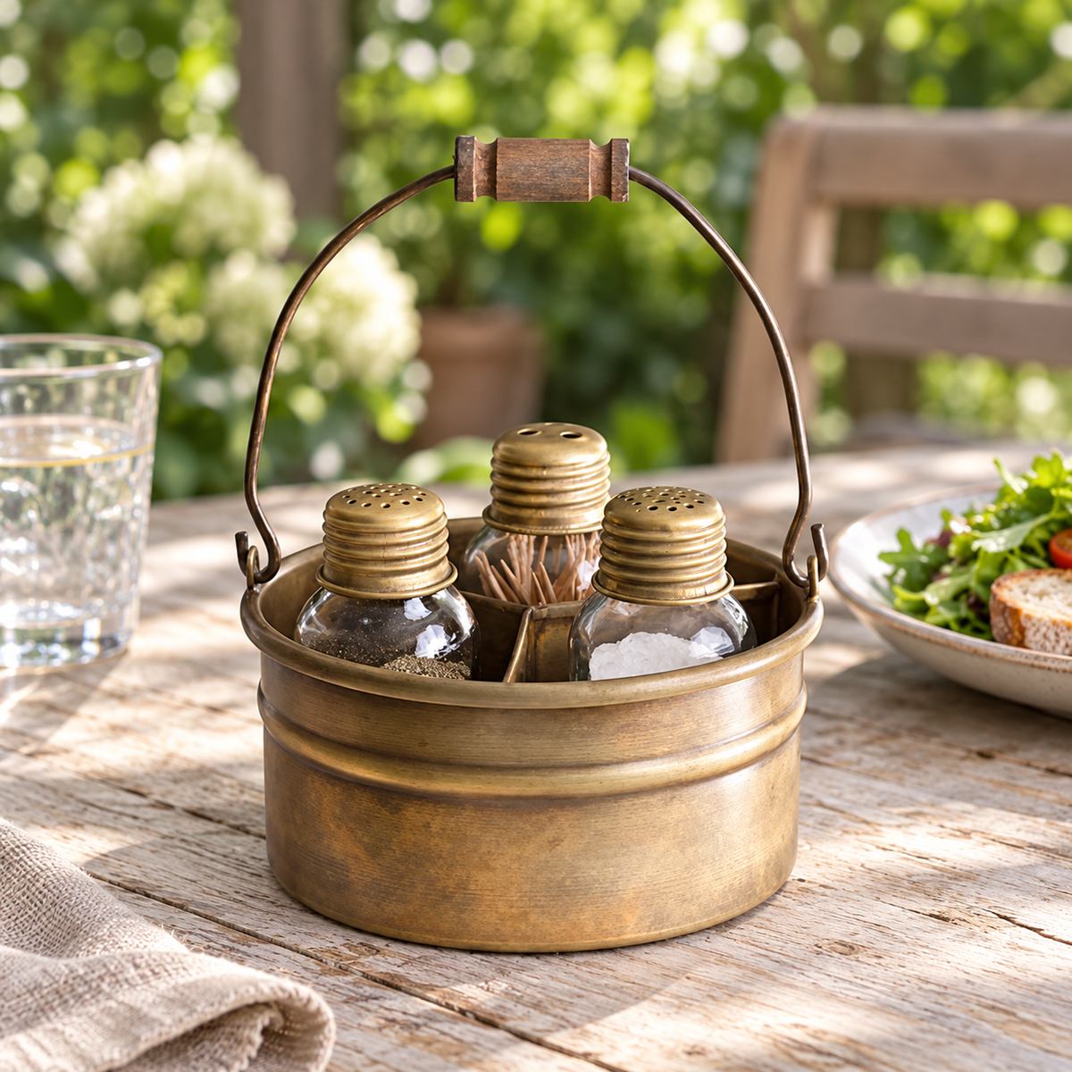 Antique-brass-finish condiment caddy at an outdoor lunch