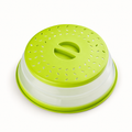 Green collapsible plate cover with leaf-shaped vents and recessed center grip on white