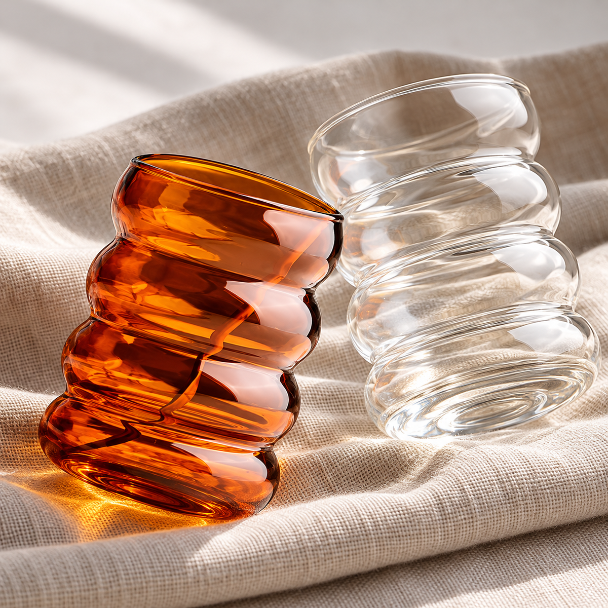 Close view of amber and clear wavy glass contours and bases