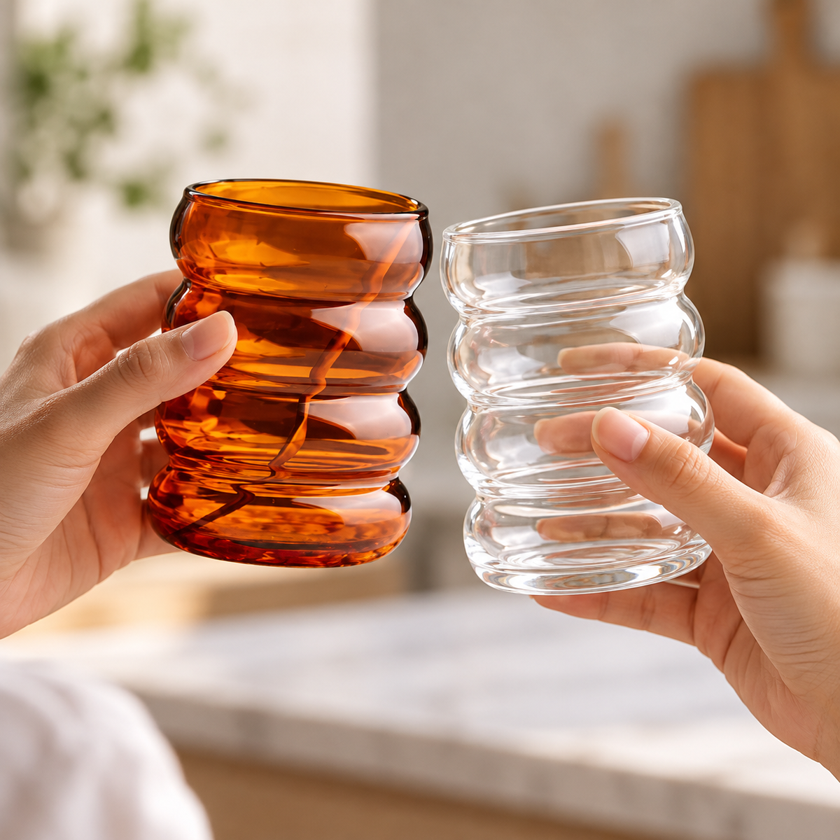 Amber and clear wavy glass cups held for scale
