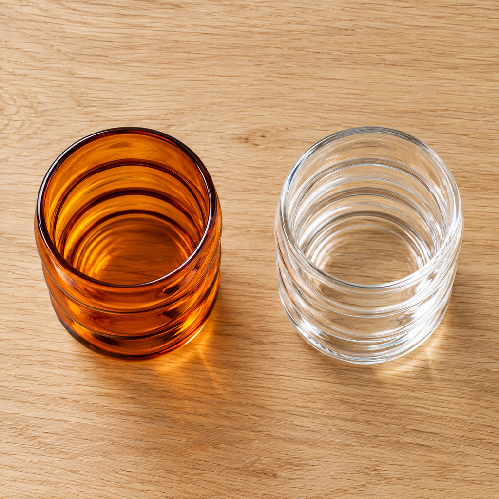 High view of the rims and interiors of amber and clear wavy glass cups