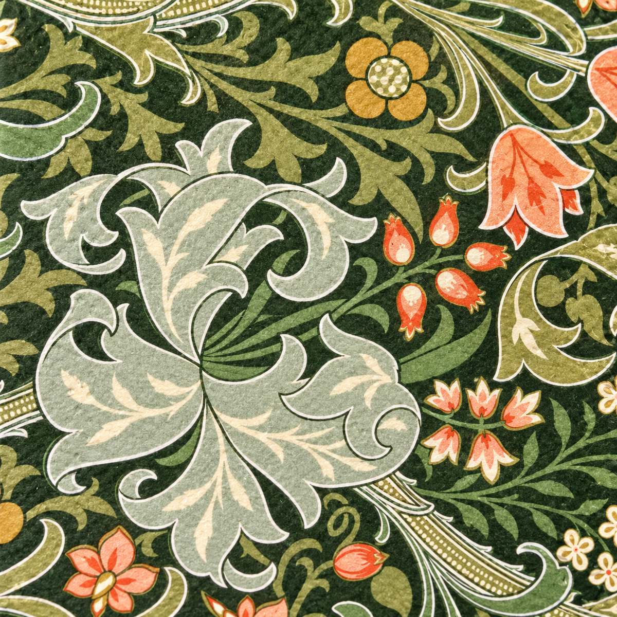 Close-up of the dark-green botanical napkin print with sage leaves, cream paisley and coral flowers.