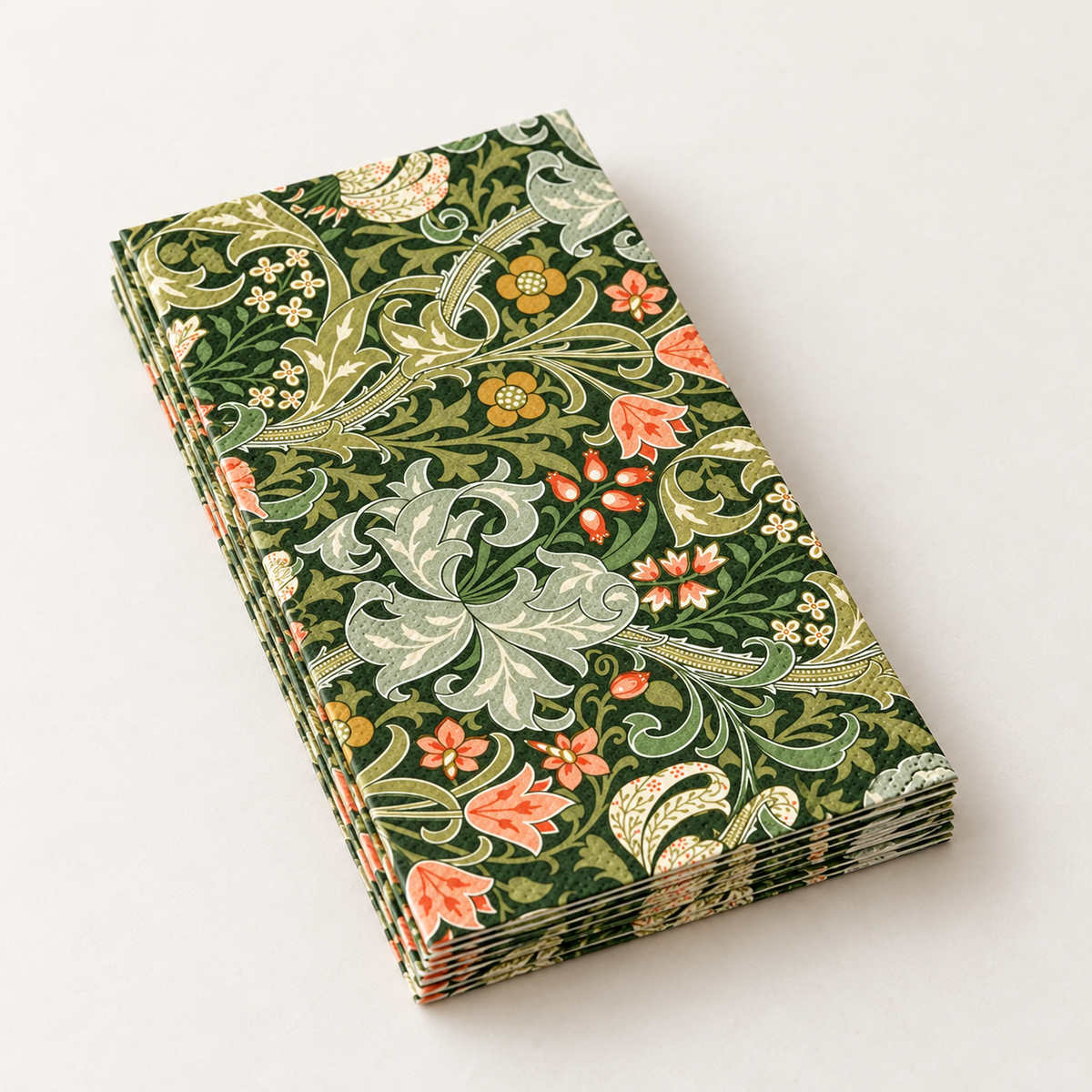 Detail of a small sample stack of folded dark-green botanical paper napkins; not a full-pack quantity display.