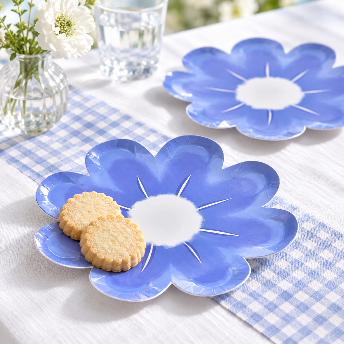 Blue flower paper plate serving two shortbread cookies on a blue-and-white dessert table. Styling props and food are not included.