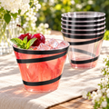 Black swirl 9 fl oz clear plastic party cups styled with punch and ice on a garden table. A partial arrangement is shown from the 300-cup pack; beverages and decorations are not included.