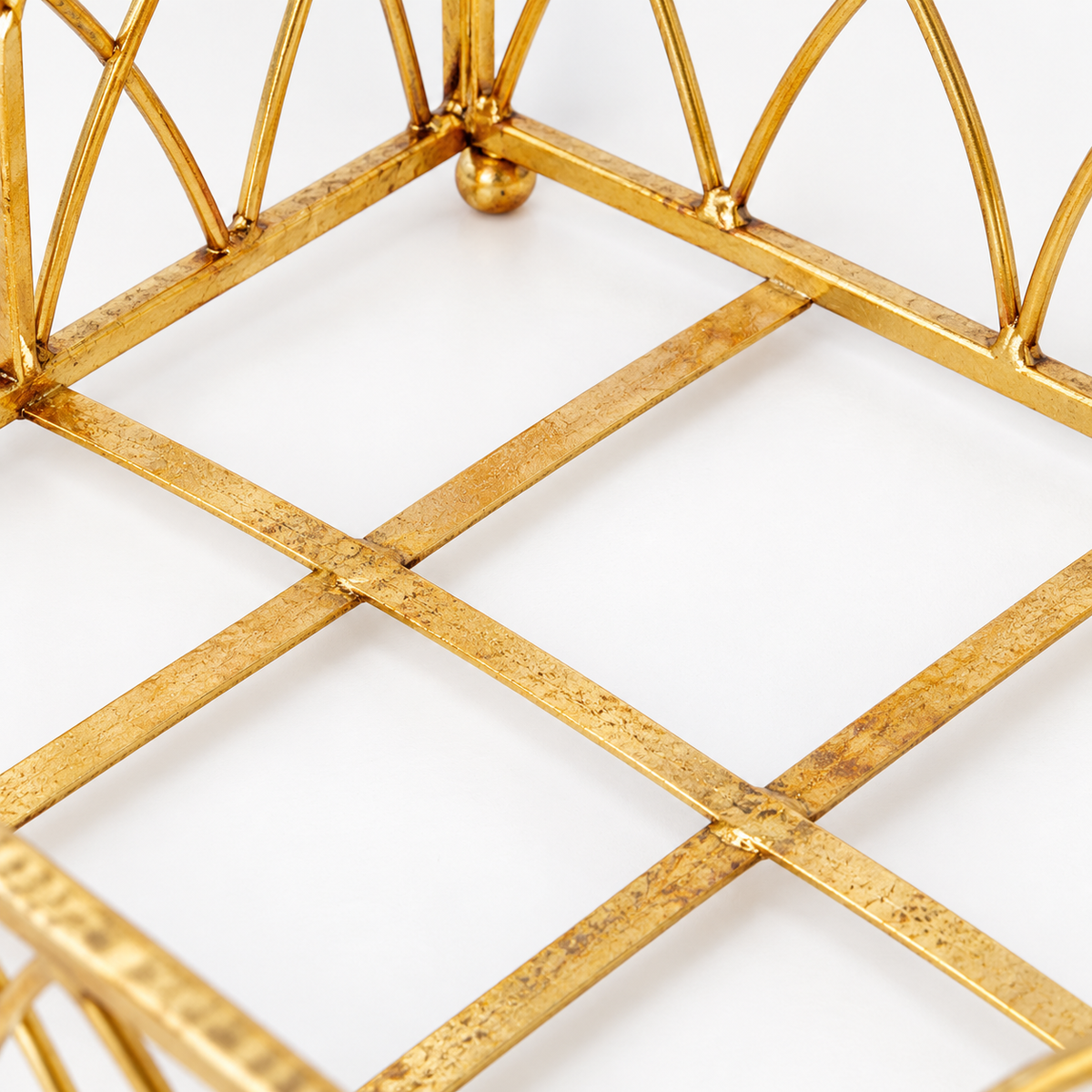 Close-up of the Gold Arch Napkin Caddy open grid metal base