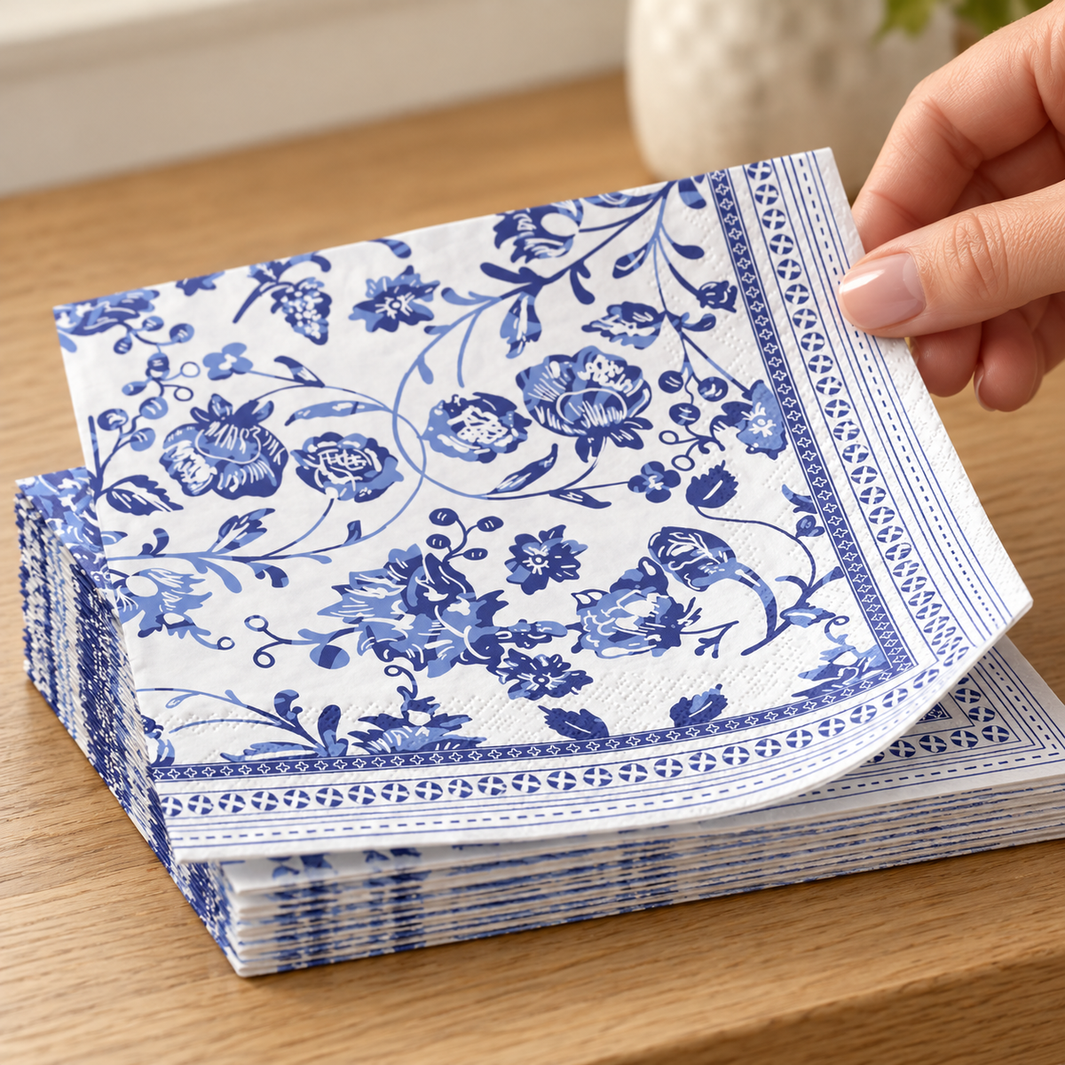Hand lifting one blue chinoiserie luncheon napkin