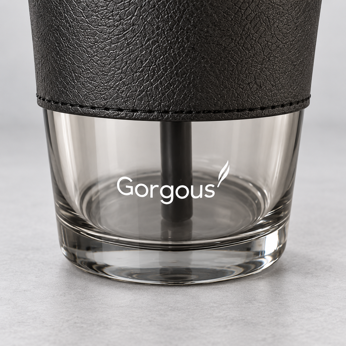 Close-up of the smoky glass cup's lower glass, flat base and white Gorgous marking.