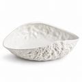 Empty asymmetrical rock-textured white ceramic soup plate on white